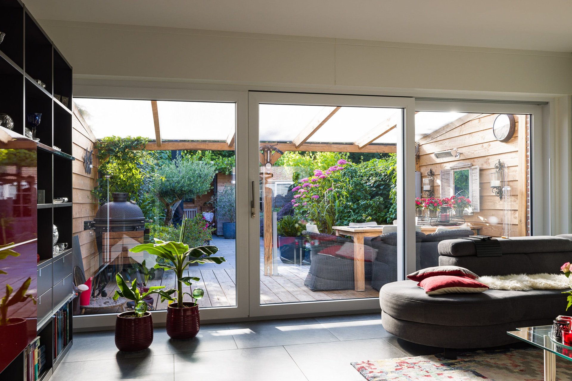 Kwaliteit Knipping kozijnen voor renovaties Moderne witte kunststof deur met glazen panelen, in een stijlvolle gevel met baksteen en raampartijen.