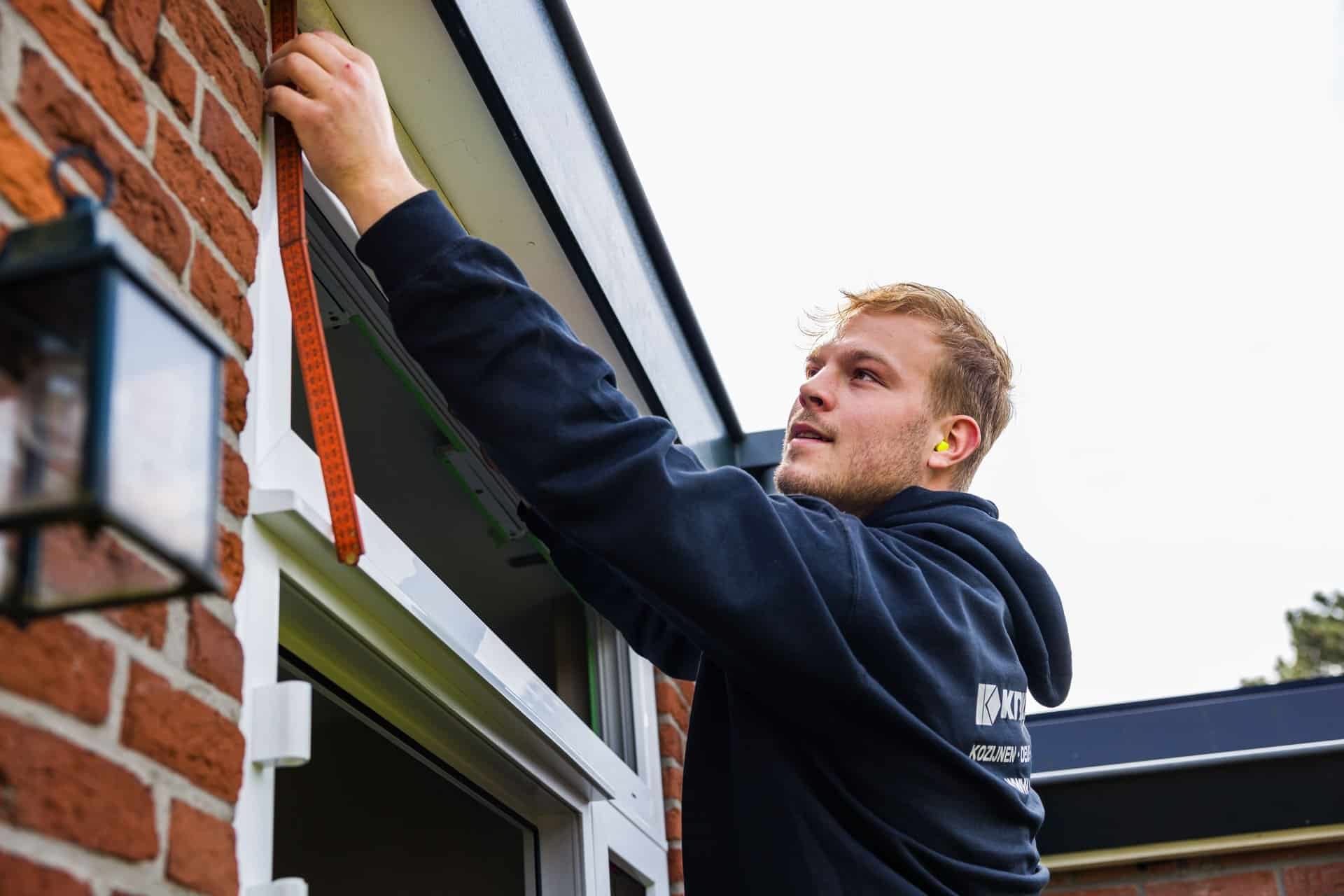 Vakkundige installatie van isolerend glas in een woningraam door professionele glaszetter.