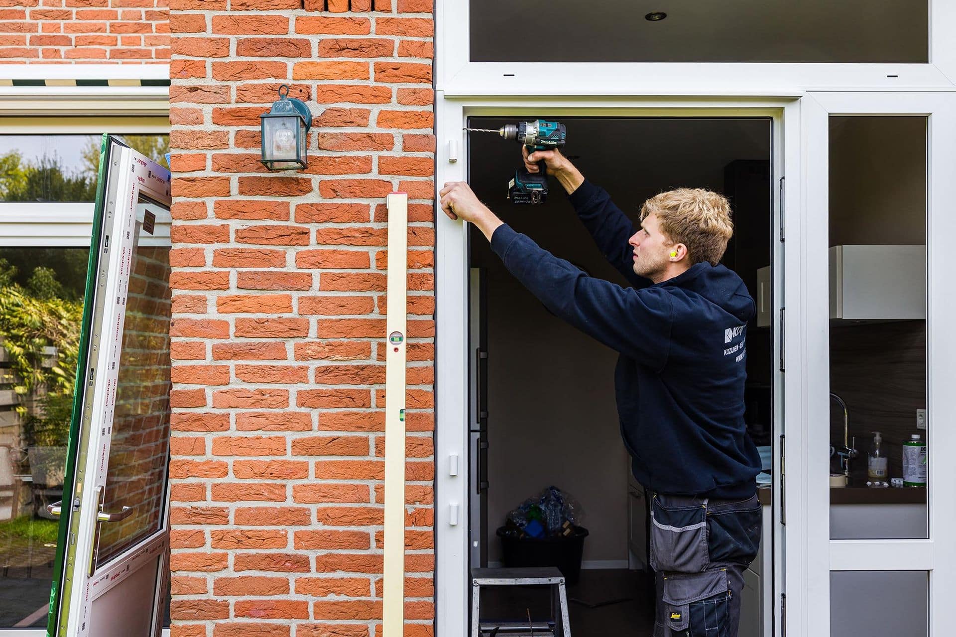 Vakman plaatst isolerend glas in raamkozijn in een huis
