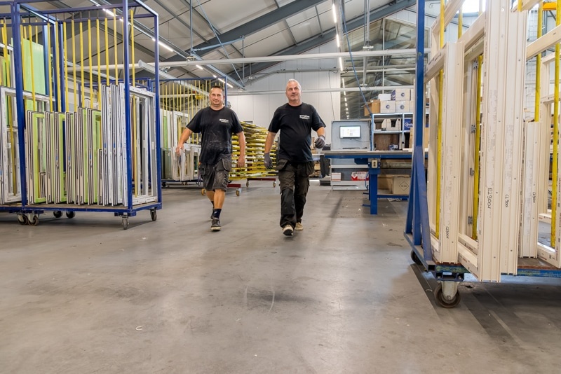 Moderne witte kunststof deur met glazen panelen bij entree van een huis.