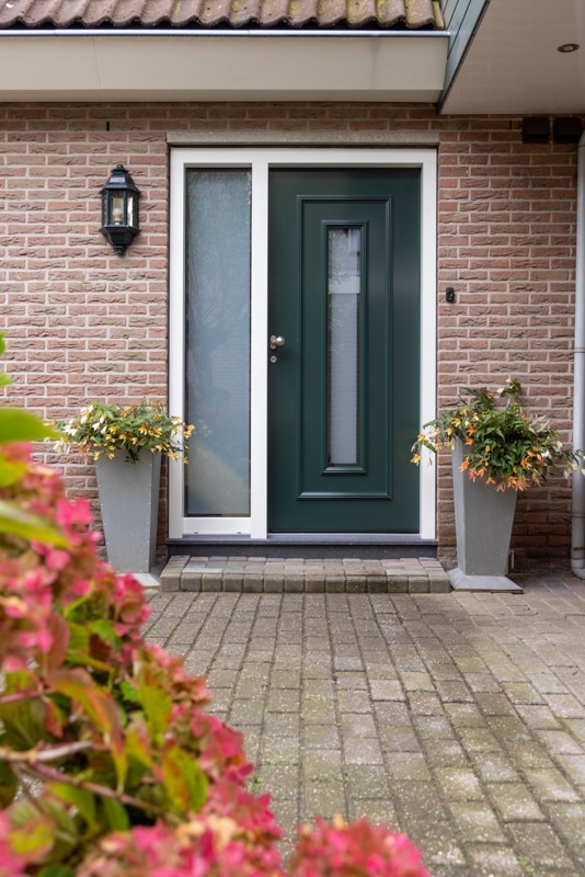 Duurzame Knipping kozijnen in renovatieproject Moderne witte schuifpui met grote ramen en zicht op een groene tuin